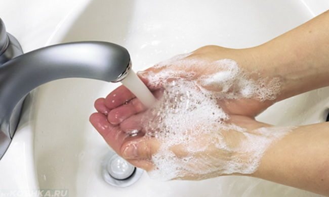 Мытье рук над белой раковиной